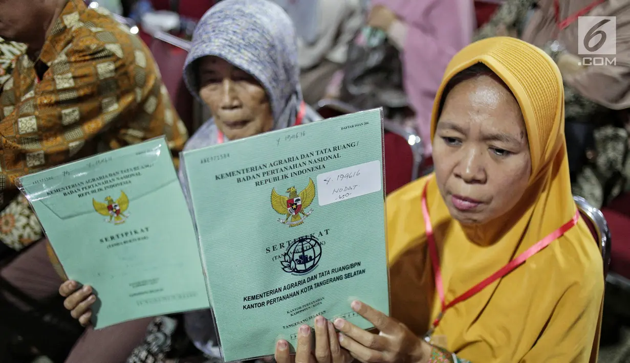 Warga menunjukkan sertifikat tanah yang baru diserahkan oleh Presiden Joko Widodo di Pusat Penerbangan Angkatan Darat, Pondok Cabe,  Tangsel, Jumat (25/1). Pada kesempatan ini, 40.172 sertifikat tanah dibagikan oleh Jokowi (Liputan6.com/Faizal Fanani)
