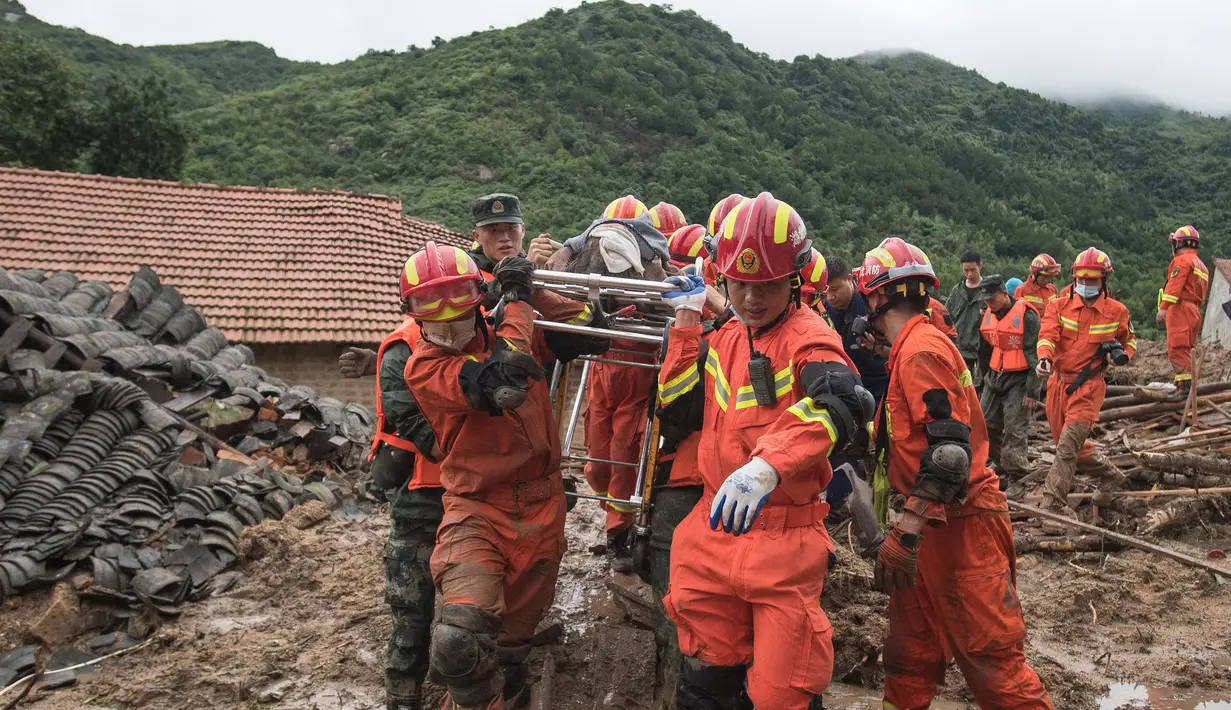 Tim penyelamat menggotong seorang wanita lanjut usia yang berhasil dikeluarkan dari puing-puing di Yuanshan, sebuah desa di Kota Dahe yang berada di Wilayah Huangmei, Provinsi Hubei, China tengah (8/7/2020). (Xinhua/Xiao Yijiu)