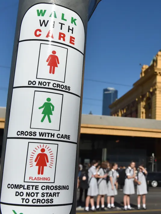 Petunjuk sinyal lalu lintas untuk pejalan kaki yang baru ditampilkan pada tiang dekat Stasiun Flinders Street pada Hari Perempuan Internasional di Melbourne, Australia, Rabu (8/3). (AFP Photo / Paul Crock)