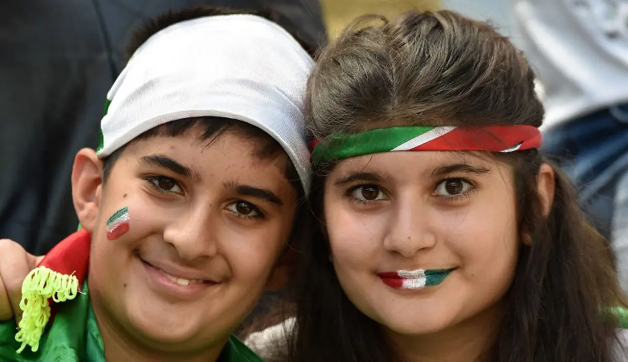 Sepasang suporter cilik "Team Melli" dengan setia menanti laga penyisihan Piala Dunia 2014 antara Iran kontra Nigeria, (16/6/2014). (AFP PHOTO/Luis Acosta)