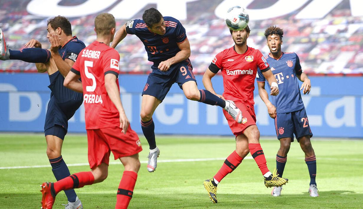 Striker Bayern Munchen, Robert Lewandowski, mencetak gol ke gawang Bayer Leverkusen pada laga Bundesliga di BayArena, Sabtu (6/6/2020). Bayern Munchen menang 4-2 atas Bayer Leverkusen. (AP/Matthias Hangst)