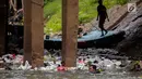 Petugas PPSU berenang untuk membersihkan tumpukan sampah yang tersangkut  di aliran anak kali Ciliwung, Jakarta, Senin (22/7/2019). Pembersihan sungai dari berbagai sampah tersebut dimaksudkan agar tidak ada penumpukan sampah dan sedimentasi saluran di sepanjang sungai. (Liputan6.com/Faizal Fanani)