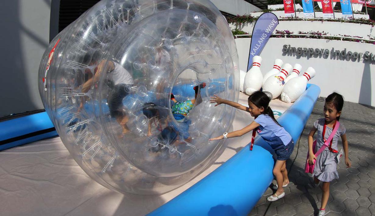 Anak-anak bermain bola raksasa yang menjadi salah satu arena bermain di Karnaval SEA Games. (Bola.com/Arief Bagus)