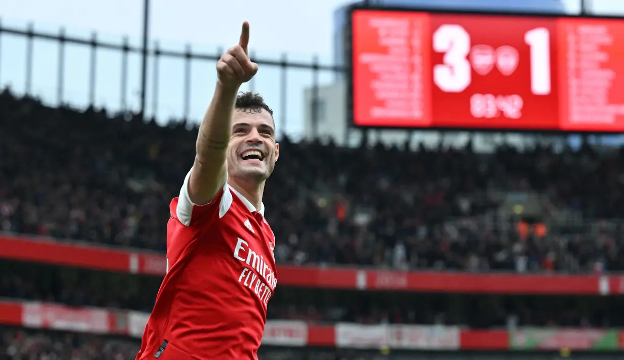 Pemain Arsenal, Granit Xhaka melakukan selebrasi setelah mencetak gol keempat timnya ke gawang Leeds United pada laga pekan ke-29 Liga Inggris 2022/2023 di Emirates Stadium, London, Minggu (02/04/2023) dini hari WIB. The Gunners menang dengan skor 4-1. (AFP/Glyn Kirk)