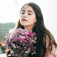 ilustrasi perempuan memegang bunga/Photo by Fa Barboza on Unsplash