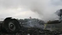 Kepulan asap tampak masih terlihat diantara reruntuhan pesawat Malaysia Airlines MH-17 yang jatuh di Grabovo, wilayah Donetsk, Ukraina , Kamis (17/7/14). (REUTERS/Maxim Zmeyev)