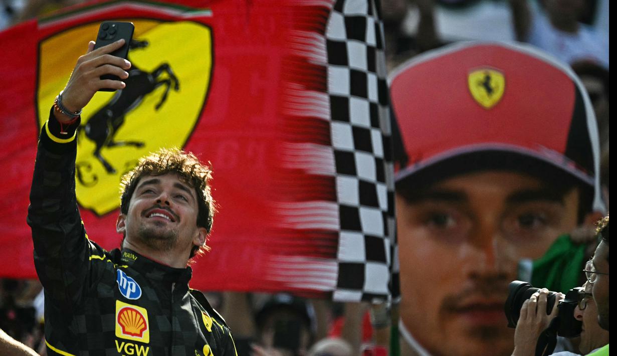 Pembalap Ferrari, Charles Leclerc melakukan swafoto saat berada di atas podium Formula 1 GP Italia 2024 yang berlangsung di Sirkuit Monza, Italia, Minggu (01/09/2024). (AFP/Gabriel Bouys)