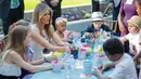 Melania Trump berbincang dengan anak-anak yang sedang mewarnai gambar saat pembukaan Taman Bunny Mellon Healing Garden Bunny Mellon di Rumah Sakit Nasional Anak di Washington, (29/4). (AP Photo/Pablo Martinez Monsivais)