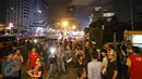 Warga tampak berkerumun di sekitar Gedung Jaya, Jalan MH Thamrin, Jakarta, setelah sebuah ledakan kembali terdengar, Kamis (14/1). Ledakan sempat membuat Jalan MH Thamrin kembali ditutup pada malam hari. (Liputan6.com/Immanuel Antonius)
