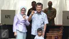 Wakil Presiden Jusuf Kalla (JK) didampingi istri, Mufidah Kalla, menunjukkan jari yang sudah dicelupkan ke tinta setelah melakukan pencoblosan Pilkada DKI 2017 di TPS 03 Kelurahan Pulo, Jakarta Selatan, Rabu (19/4). (Liputan6.com/Herman Zakharia)