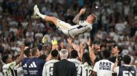 Pemain Real Madrid melemparkan Toni Kroos ke udara saat upacara perpisahan untuk sang pemain setelah laga Liga Spanyol 2023/2024 melawan Real Betis di Santiago Bernabeu, Madrid, Spanyol, Minggu (26/05/2024) dini hari WIB. Kroos memutuskan untuk pensiun dari sepak bola setelah Euro 2024 nanti. (AFP/Javier Soriano)