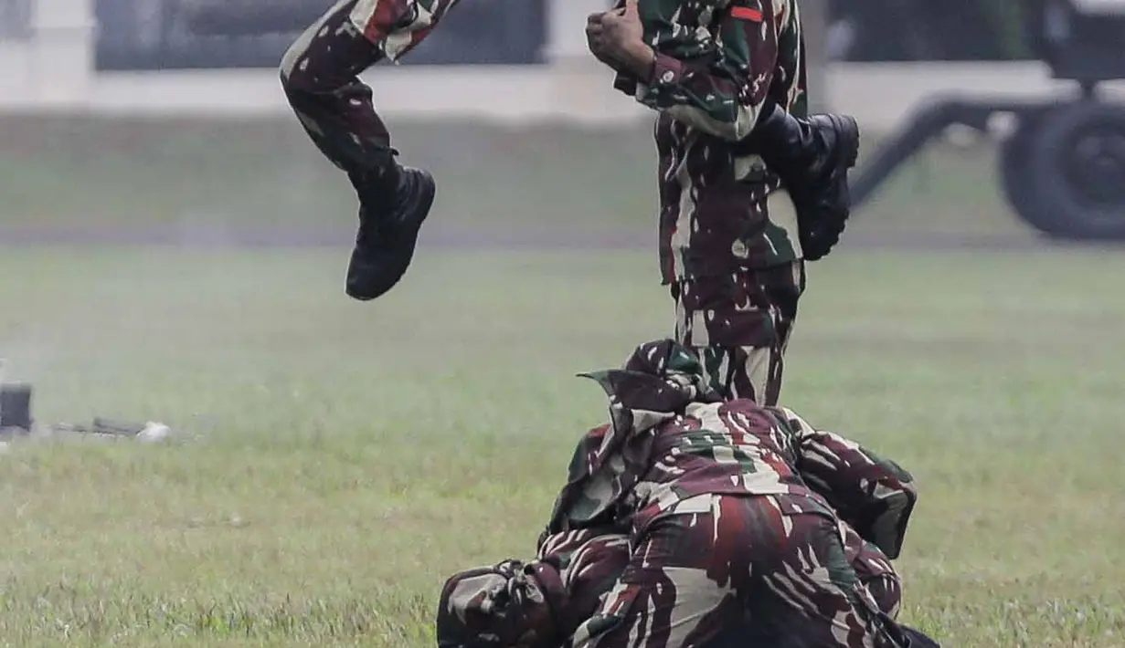 Personel Kopassus menunjukkan gerakan bela diri saat upacara penyerahan satuan Kopassus di Lapangan Mako Kopassus dari Mayjen TNI Madsuni kepada Mayjen TNI Eko Margiyono di  Lapangan Mako Kopassus, Jakarta, Jumat (23/3). (Liputan6.com/Faizal Fanani)