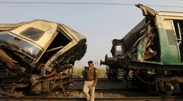 Polisi berjalan diantara gerbong yang rusak parah usai kecelakaan yang melibatkan dua kereta penumpang di Palwal, India, Selasa (8/12). Menurut media setempat, kejadian itu menewaskan satu orang dan puluhan lainnya luka parah. (REUTERS/Anindito Mukherjee)