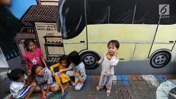 Anak-anak bermain di depan gambar mural/grafiti di Kampung Bekelir, Jalan Perintis Kemerdekaan, Kota Tangerang, Banten, Selasa (17/4). Kampung Bekelir disulap menjadi kampung warna-warni dengan gambar mural/grafiti. (Merdeka.com/Arie Basuki)