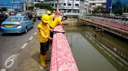 Pekerja melakukan pengecatan Jembatan Merah di Jalan Pangeran Jayakarta, Jakarta, Selasa (27/12). Jembatan yang sebelumnya terlihat usang dan kusam kini terlihat lebih rapih dan bersih. (Liputan6.com/Gempur M. Surya)