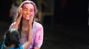 Seorang siswa tunanetra dari The Devnar School for the Blind memberikan bubuk warna pada seorang guru ketika mereka merayakan festival Holi di Hyderabad, India (21/3). (AFP Photo/Noah Seelam)