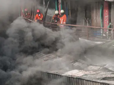 Petugas pemadam kebakaran berusaha memadamkan api yang membakar kios di bangunan Blok I dan Blok II Pasar Senen di Jakarta, Kamis (19/1). Kebakaran di Pasar Senen tersebut dilaporkan terjadi sekitar pukul 04.43 WIB. (Liputan6.com/Gempur M Surya)