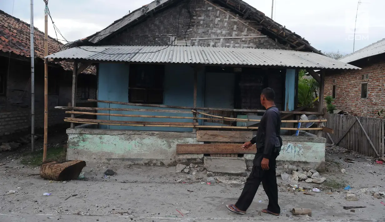 Seorang warga melihat kondisi rumah yang ditinggalkan di dusun Regahan Lada, Pulau Sebesi, Lampung, Senin (31/12). Banyak warga dusun ini yang bertahan di lokasi pascatsunami yang melanda Selat Sunda pada 22 Desember lalu. (Liputan6.com/Herman Zakharia)