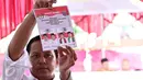 Petugas mengeluarkan surat suara para calon untuk dilakukan suara Pilkada serentak di TPS Kampung Pilkada RW 03, Depok, Jawa Barat, (9/12). (Liputan6.com/Immanuel Antonius)