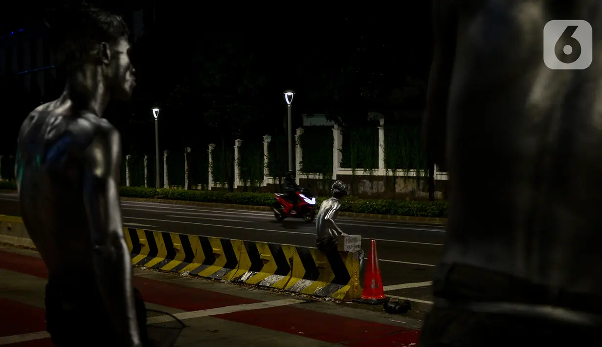 Manusia silver saat menghibur pengendara bermotor di perempatan kawasan Senayan, Jakarta, Sabtu (9/5/2020). Meskipun di tengah pandemi Covid-19, para manusia silver ini masih tetap melakukan aksinya di jalanan untuk memenuhi kebutuhan sehari-hari. (merdeka.com/Imam Buhori)