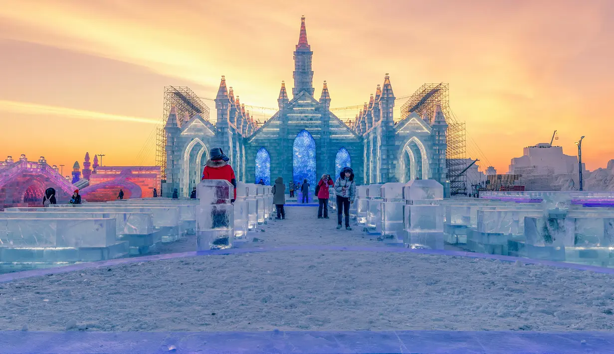 Foto pada 24 Desember 2018 menunjukkan orang-orang mengunjungi Harbin Ice Snow World di Harbin, provinsi Heilongjiang, China. Festival ini sendiri merupakan festival yang digelar setiap datangnya musim dingin di sana. (STR / AFP)