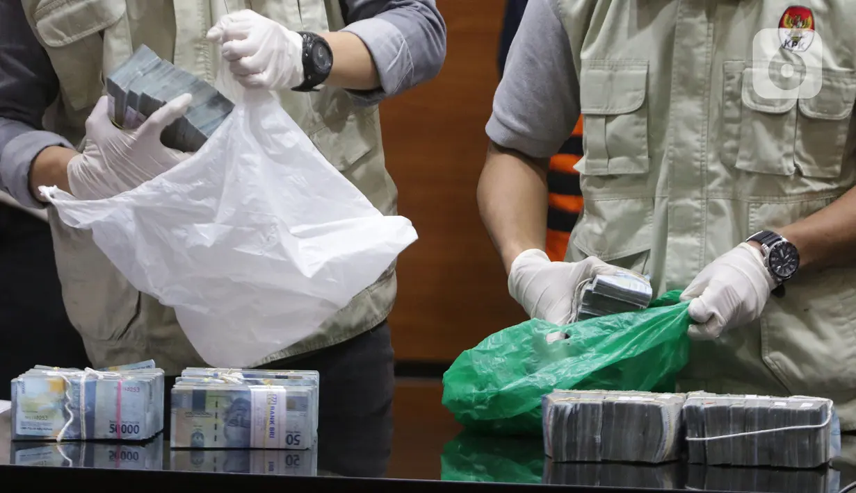 Petugas KPK menunjukkan barang bukti penangkapan tiga tersangka suap terkait pengadaan barang dan jasa di Kab Hulu Sungai Utara Kalimantan Selatan 2021-2022 di Gedung KPK Jakarta, Kamis (16/9/2021). Ketiganya terkena OTT KPK berikut barang bukti uang Rp 345 juta. (Liputan6.com/Hemi Fithriansyah)