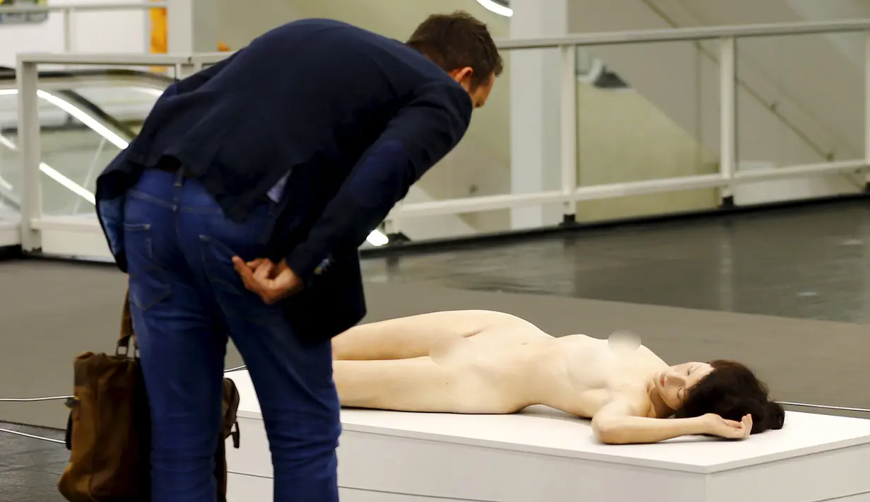 Seorang pria saat melihat patung karya John de Andrea yang bernama " Lisa " selama Art Cologne 2016 di Jerman 15 April 2016. Patung yang sangat menyerupai manusia ini terbuat dari perunggu, minyak olychromed dan rambut asli. (REUTERS / Wolfgang Rattay)