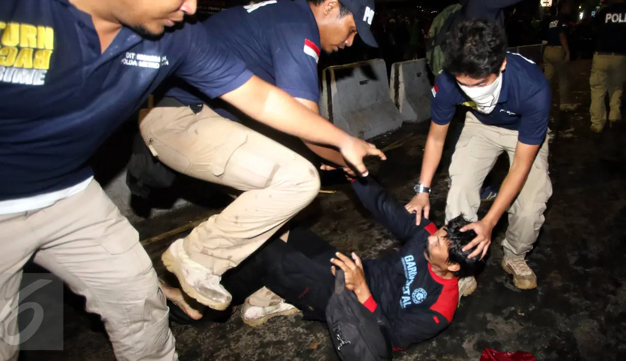 Polisi menangkap buruh yang berusaha melawan di depan Istana Merdeka, Jakarta, Jumat (30/10/2015). Pembubaran tersebut merupakan prosedur tetap dari kepolisian yang telah diatur dalam undang-undang. (Liputan6.com/Immanuel Antonius)