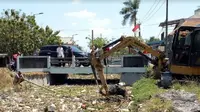 Pemerintah Kabupaten (Pemda Sidoarjo) menerjunkan satu alat berat eskavator dan enam dump truk pengangkut sampah untuk benahi aliran Sungai Gedangan. (Foto:Liputan6.com/Dian Kurniawan)