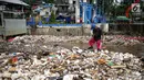 Petugas membersihkan sampah yang menyumbat Pintu Air Manggarai, Jakarta, Selasa (26/2). Meningkatnya debit air Sungai Ciliwung menyebabkan terjadi penumpukan sampah di Pintu Air Manggarai. (Liputan6.com/Faizal Fanani)