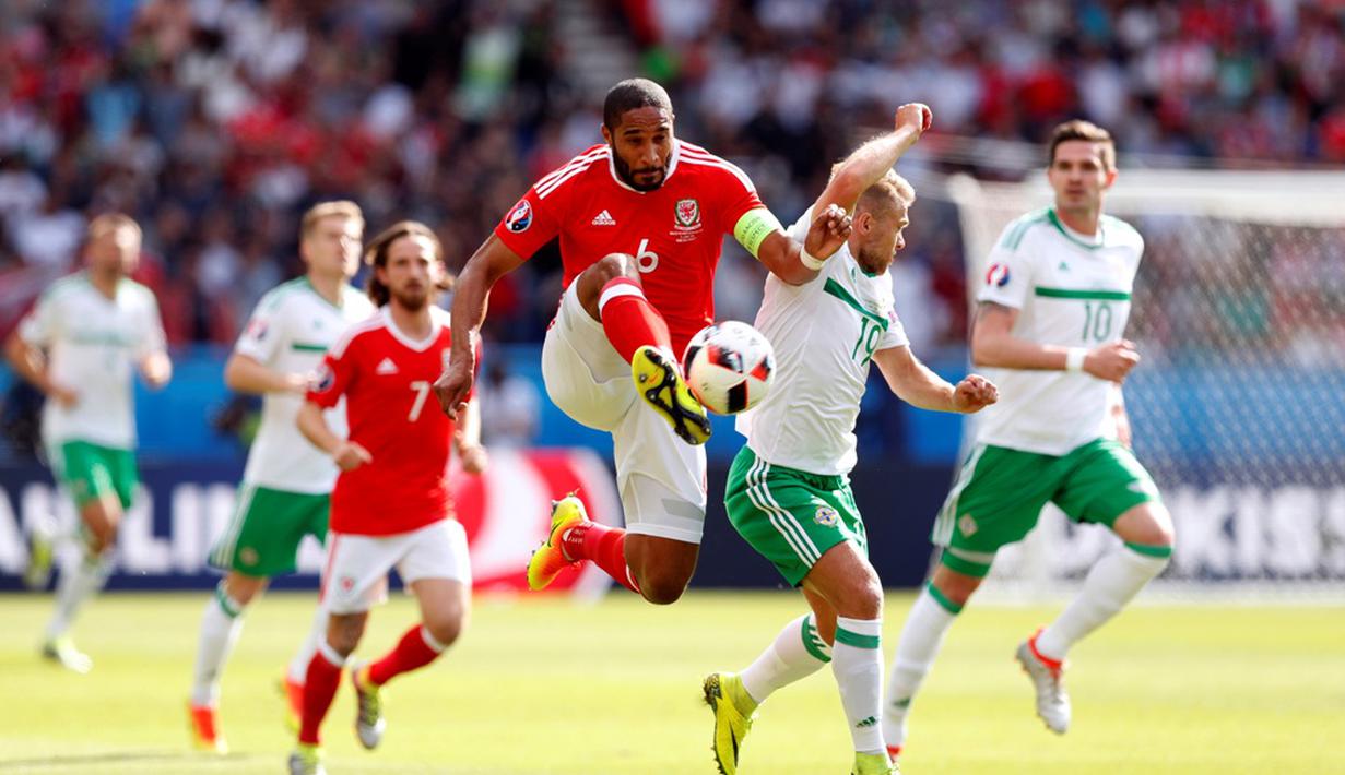 Pemain Wales, Ashley Williams, berebut bola dengan pemain Irlandia Utara, Jamie Ward, pada laga 16 besar Piala Eropa 2016 di Parc des Princes, Paris, Sabtu (25/6/2016) malam WIB. (Reuters/John Sibley)