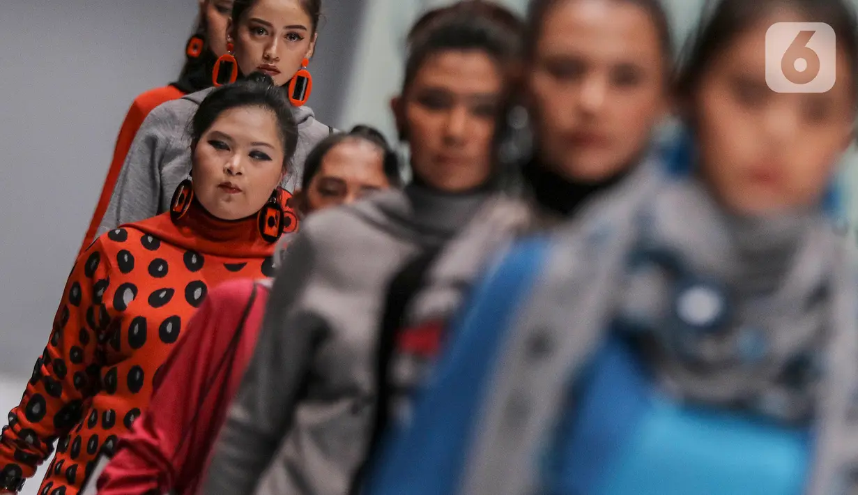 Model disabilitas memperagakan busana rancangan kolaborasi Cotton Ink x Intoart yang digawangi British Council pada Jakarta Fashion Week 2020 di Senayan, Kamis (24/10/2019). Kolaborasi ini menampilkan model disabilitas yang terdiri dari down syndrome, tuna daksa dan tuli. (Liputan.com/Johan Tallo)