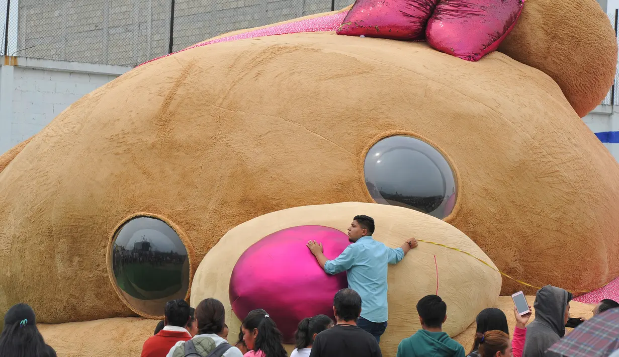 Panitia dibantu pejabat setempat mengukur boneka beruang teddy (Teddy Bear) berukuran raksasa di Xonacatlan, Meksiko (28/4/2019). Boneka berukuran 20 meter persegi dengan berat 4 ton, masuk dalam Guinness Book of World Records. (Mario Vazquez / AFP)