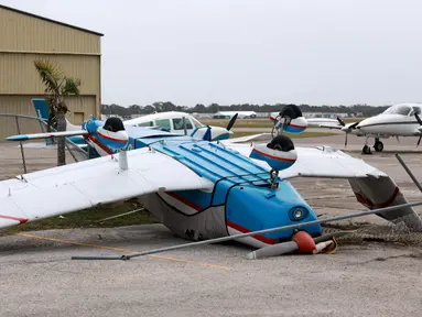 Sebuah pesawat terbang terbalik di Bandara Kota Venice setelah Badai Milton melewati area tersebut pada 11 Oktober 2024, di Venice, Florida. (Joe Raedle/Getty Images North America/Getty Images via AFP)