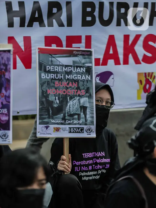 Pengunjukrasa dari Serikat Buruh Migran Indonesia membawa poster dalam aksi di depan Kementerian Ketenagakerjaan, Jakarta, Rabu (18/12/2019). Aksi  memperingati Hari Buruh Migran Internasional itu mendesak Negara bertanggung jawab atas perlindungan hak buruh migran. (Liputan6.com/Faizal Fanani)