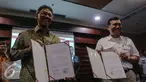Luhut Binsar Pandjaitan (kanan) dan Ardan Adi Perdana  memperlihatkan MoU di Gedung Bina Graha, Jakarta, Jumat (10/7/2015).  MoU ini akan menjadi landasan pengawasan serta pengendalian 100 program prioritas Presiden Jokowi. (Liputan6.com/Faizal Fanani)