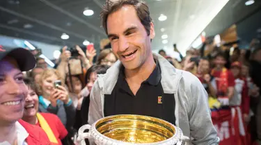 Petenis Swiss Roger Federer membawa trofi Australia Terbuka saat disambut penggemar di Bandara Zurich, di Kloten, Swiss, (30/1). Federer memenangkan final tunggal putramelawan petenis Kroasia Marin Cilic. (Ennio Leanza/Keystone via AP)