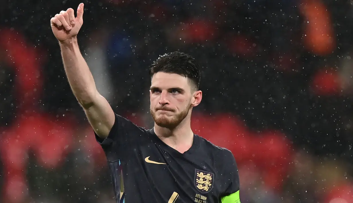 Declan Rice yang tengah menjalani musim pertamanya berseragam Arsenal menjadi pemain The Gunners teranyar yang ditunjuk sebagai kapten Timnas Inggris. Momen itu terjadi saat Timnas Inggris bermain imbang 2-2 dengan tamunya Belgia pada laga uji coba jelang Euro 2024 (26/3/2024). Dalam laga ke-50 bersama Timnas Inggris tersebut, Declan Rice memakai ban kapten menggantikan Harry Kane dan Kyle Walker yang tak dipanggil pelatih Gareth Southgate akibat tengah mengalami cedera. (AFP/Glyn Kirk)