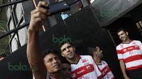 Suporter Madura United FC mengajak berselfie-ria pemain asing Fabiano Beltrame, Toni Espinosa Mossi, dan Pablo Rodriguez Aracil di Stadion Ahmad Yani, Sumenep, Sabtu (20/2/2016). (Bola.com/Vitalis Yogi Trisna)