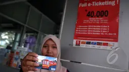 Seorang pengguna bus Transjakarta memperlihatkan kartu e-ticketing, Jakarta, Sabtu (21/2/2015). PT Transportasi Jakarta (Transjakarta) menyatakan seluruh 12 koridor Transjakarta resmi menggunakan e-ticketing. (Liputan6.com/JohanTallo)