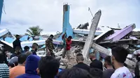 Tim penyelamat mencari korban usai gempa meruntuhkan Rumah Sakit Mitra Manakarra, Kota Mamuju, Sulawesi Barat, Indonesia, Jumat (15/1/2021). Sebanyak 20 pasien dan staf terjebak di bawah reruntuhan bangunan. (Firdaus/AFP)