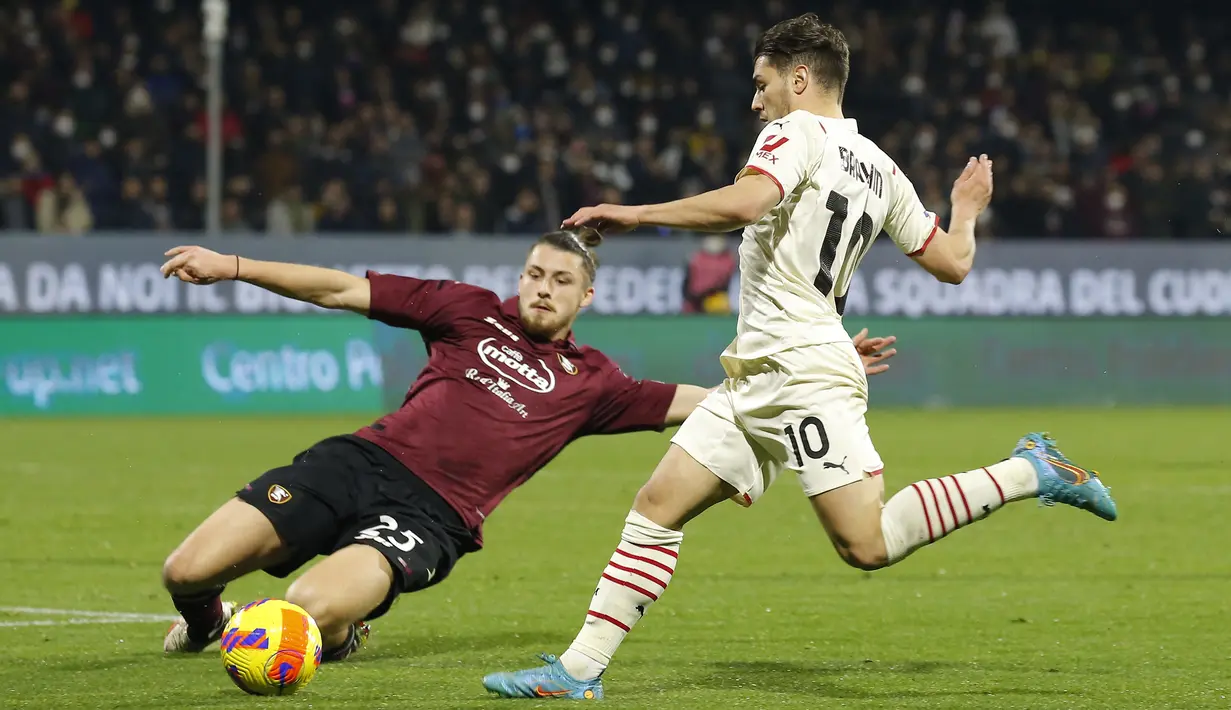 Bek Salernitana Radu Dragusin (kiri) menjegal gelandang AC Milan Brahim Diaz pada giornata ke-26 Liga Italia di Stadion Arechi, Salerno, Minggu (20/2/2022) dini hari WIB. Sempat unggul terlebih dahulu, AC Milan harus puas bermain imbang 1-1. (CARLO HERMANN/AFP)