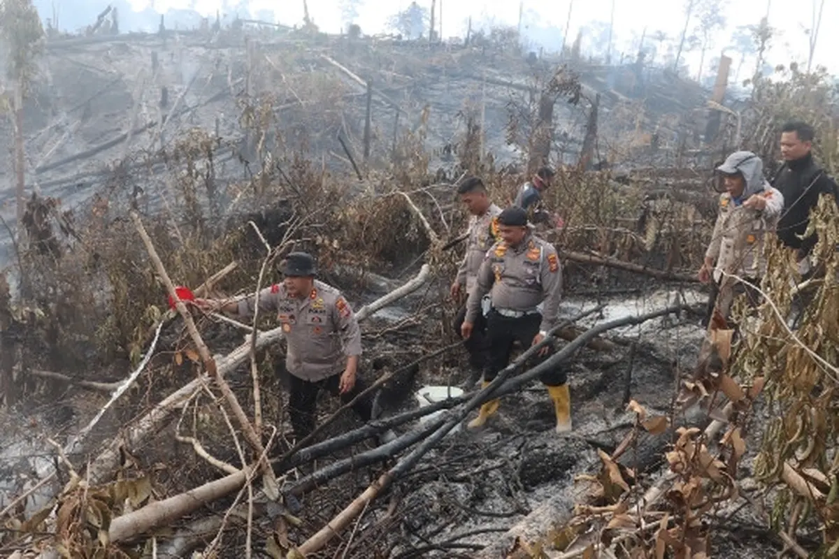 Polisi di Indragiri Hulu mendinginkan lokasi kebakaran lahan yang sudah padam agar api tidak muncul lagi.