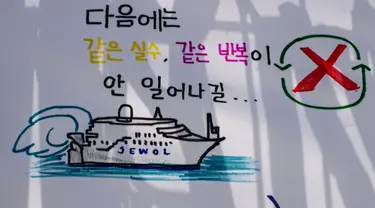 Sebuah gambar yang menggambarkan kapal feri Sewol dengan tulisan yang diterjemahkan sebagai "Saya harap kesalahan yang sama tidak akan terjadi lagi di lain waktu", di sebuah pelabuhan di Mokpo, Provinsi Jeolla Selatan, pada tanggal 16 April 2024. (ANTHONY WALLACE/AFP)