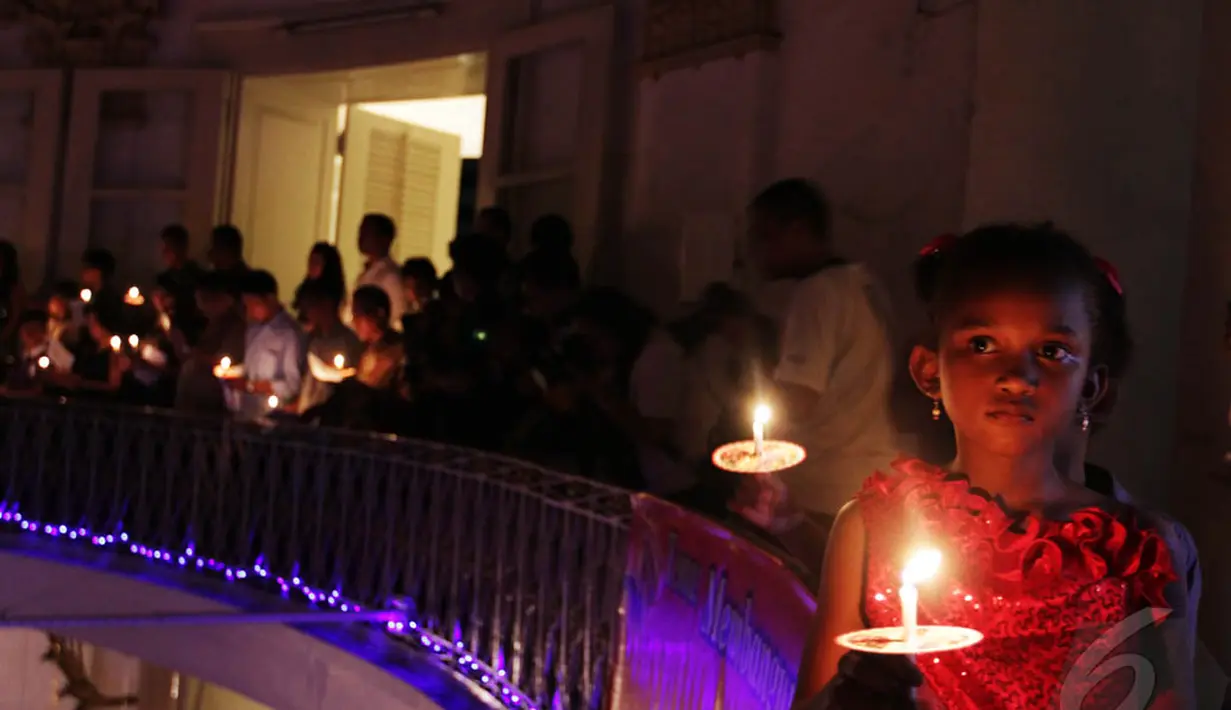 Seorang anak menyalakan lilin ketika mengikuti Misa Natal di Gereja Immanuel Jakarta, Rabu (24/12/2014). (Liputan6.com/Faizal Fanani)