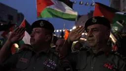 Petugas otoritas Palestina memberikan hormat saat menunggu live-screening pidato Presiden Mahmud Abbas sebelum pengibaran bendera Palestina di markas besar PPB di New York, Rabu (30/9/2015). (AFP PHOTO/ABBAS Momani)