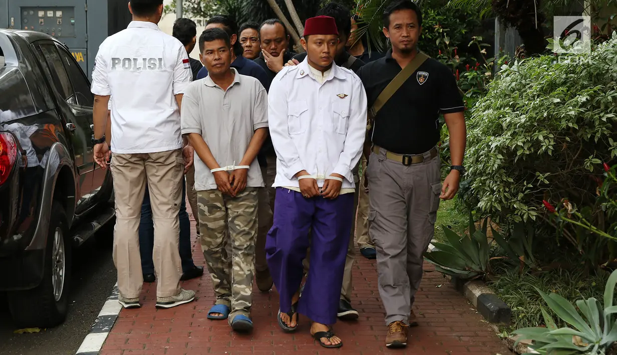 Petugas membawa dua terduga pelaku persekusi U dan M di Polda Metro Jaya, Jakarta, Jumat (2/6). Reskrim Polres Jaktim menangkap dua pelaku persekusi terhadap PMA, 15 tahun, karena diduga menghina FPI dan Rizieq Syihab. (Liputan6.com/Immanuel Antonius)