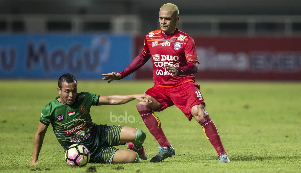 Striker Arema FC, Cristian Gonzales, berebut bola dengan gelandang PS TNI, Guntur Triaji, pada laga Liga 1 di Stadion Pakansari, Bogor, Senin (3/7/2017). Kedua klub bermain imbang 0-0. (Bola.com/Vitalis Yogi Trisna)