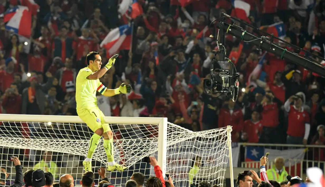 Claudio Bravo merayakan gelar juara dengan naik ke atas mistar gawang. (AFP PHOTO/PABLO PORCIUNCULA)
