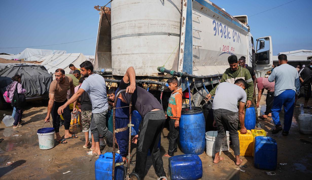 Situasi ini mengakibatkan lumpuhnya sistem air sekaligus dan mengancam kehidupan pengungsi Palestina di Gaza. Tampak dalam foto, para pengungsi Palestina berkumpul untuk mengambil air dari sebuah truk di kamp tenda darurat, Khan Younis, Jalur Gaza Selatan, Kamis 30 April 2026. (AP Photo/Abdel Kareem Hana)